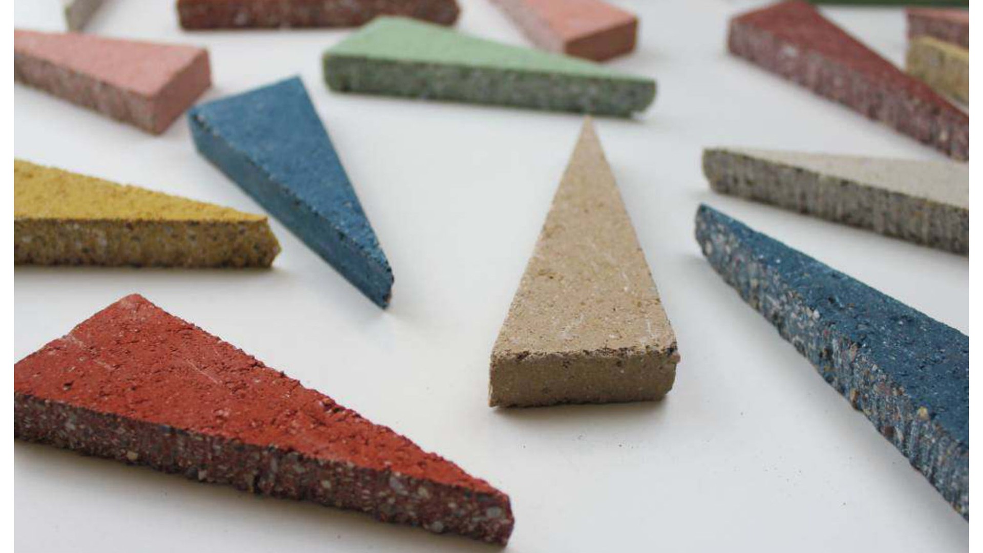 Muestras de baldosas minerales recicladas azules, rojas, verdes y neutras que muestran bordes de agregados expuestos