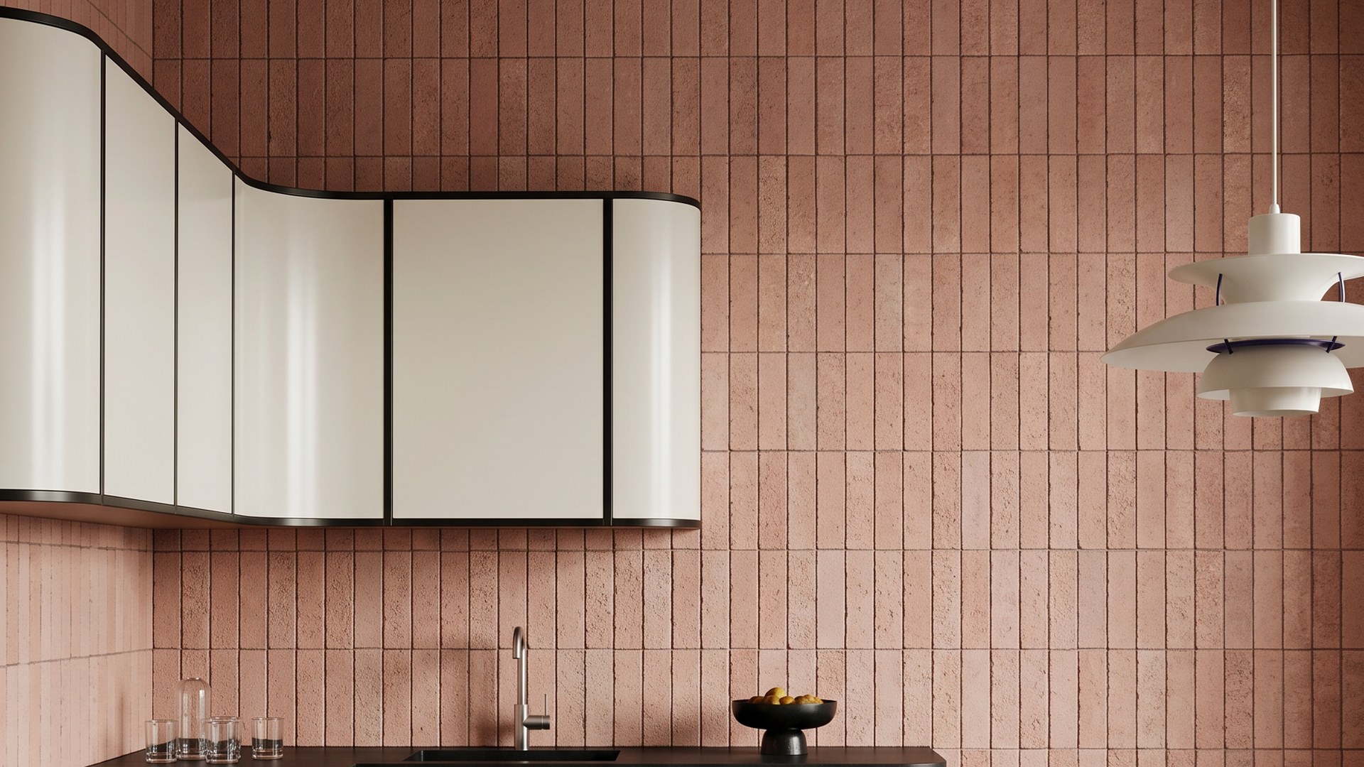 Baldosas minerales de terracota instaladas como una pared de cocina de altura completa detrás de gabinetes curvos pálidos