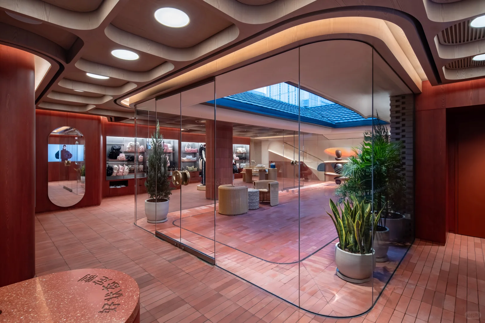 Glass-lined retail interior with red tiled flooring and curved ceiling details