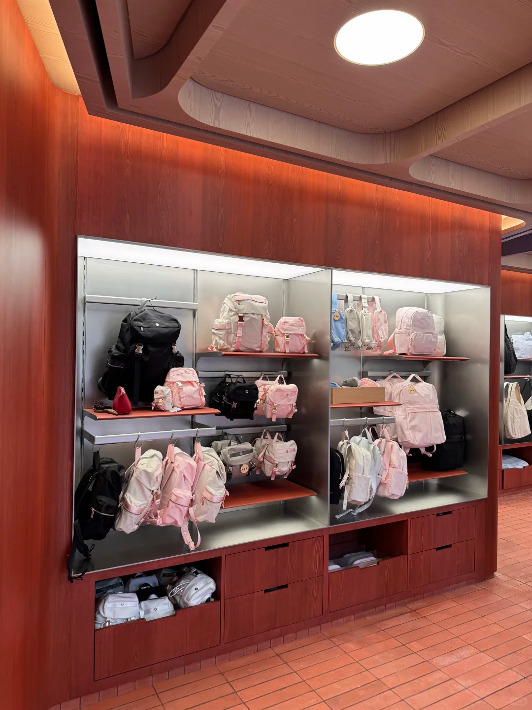 Backpacks displayed on recessed shelves above a red tiled floor